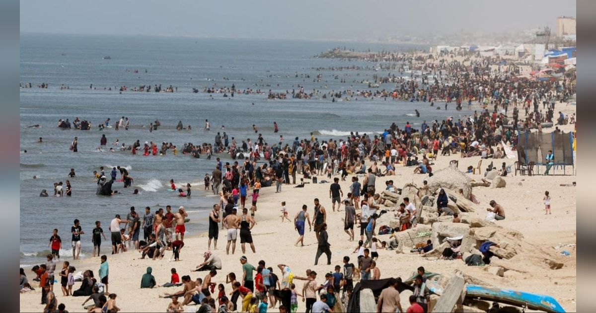 FOTO: Jernihkan Pikiran dari Trauma Perang, Warga Palestina Bondong-Bondong Padati Pantai Gaza saat Musim Panas
