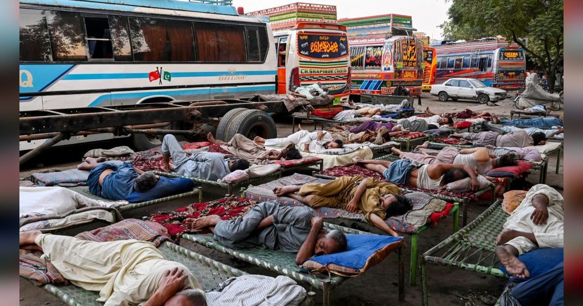 FOTO: Di Tengah Gelombang Suhu Panas Ekstrem, Sopir Bus di Pakistan Ini Justru Tidur Nyenyak di Luar Ruangan