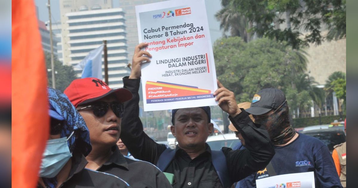 FOTO: Panas-Panasan Demo di Patung Kuda, Massa Buruh Tuntut Penghentian Ancaman PHK Besar-Besaran