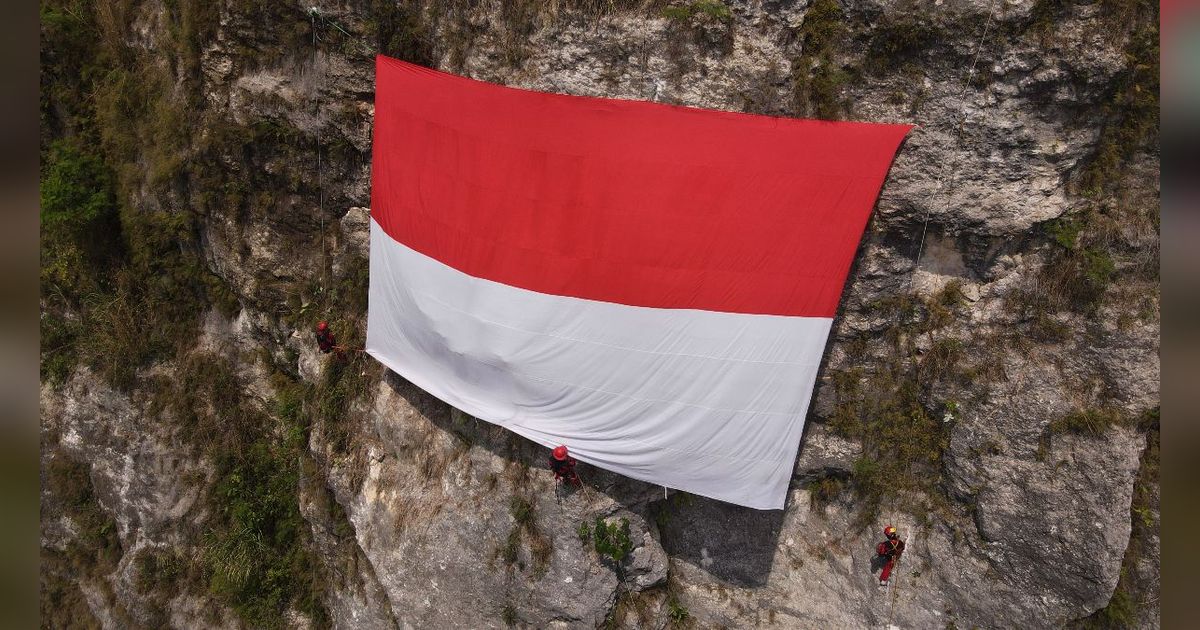 FOTO: Penampakan Gagahnya Merah Putih Raksasa Terbentang di Tebing Gua Lalay Bogor