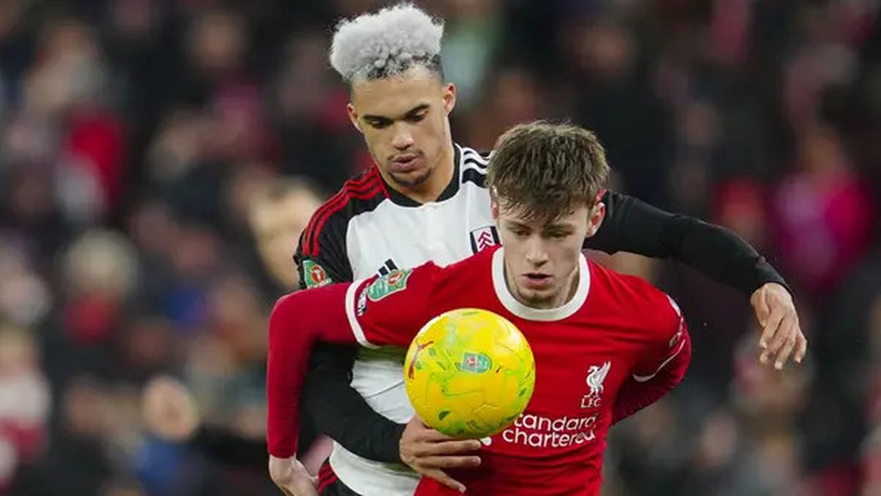 Bek Liverpool, Conor Bradley (depan) menguasai bola dibayangi bek Fulham, Antonee Robinson pada laga leg pertama babak semifinal Carabao Cup 2023/2024 di Anfield Stadium, Liverpool, Kamis (11