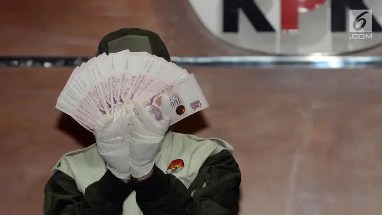 Petugas menunjukkan barang bukti berupa pecahan uang Dolar Singapura hasil OTT hakim Pengadilan Negeri Jakarta Selatan saat konferensi pers di gedung KPK, Jakarta, Rabu (28/11). Dalam kasus t