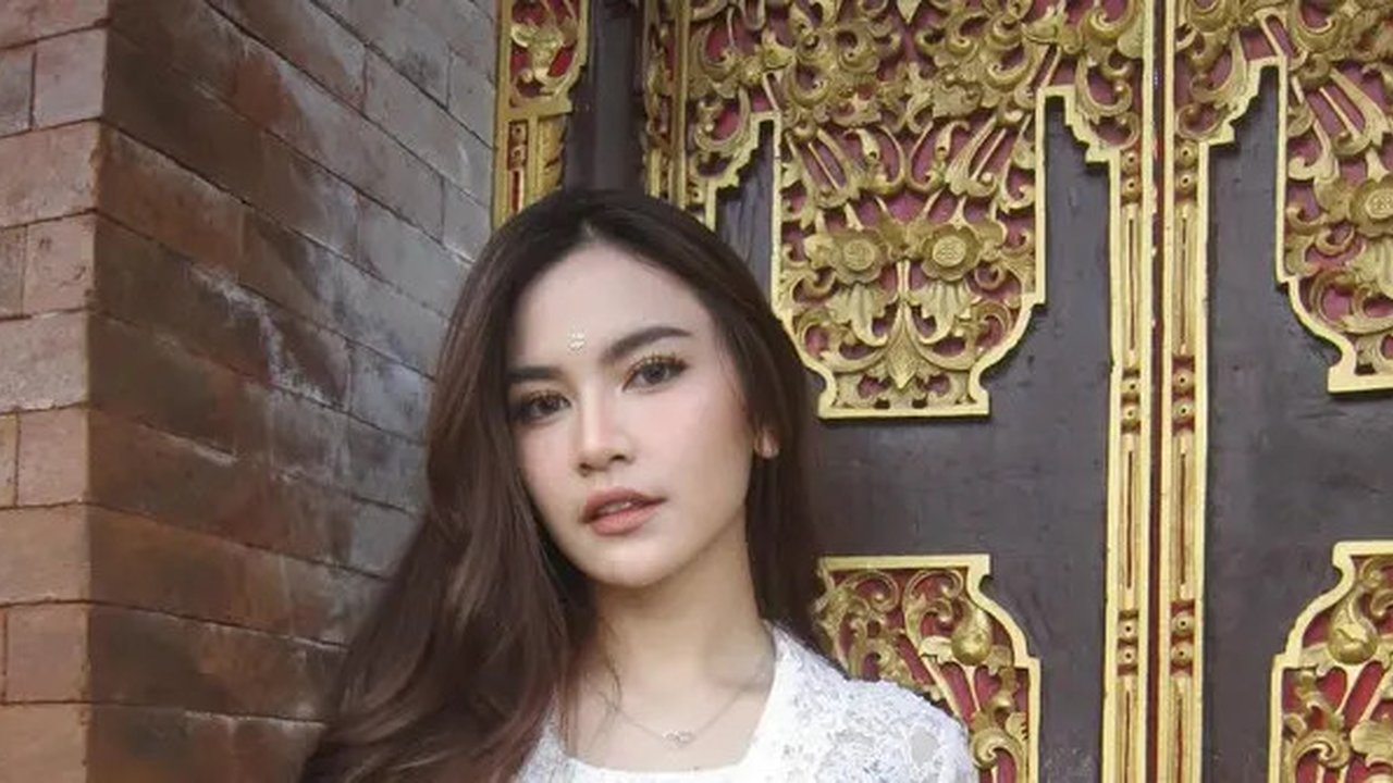 Manisnya penampilan Mahalini Raharja pakai kebaya Bali berwarna putih polos, dipadukannya mengenakan kain wastra bernuansa ungu wine dan selendangnya yang senada, yang diikatkannya di pinggan
