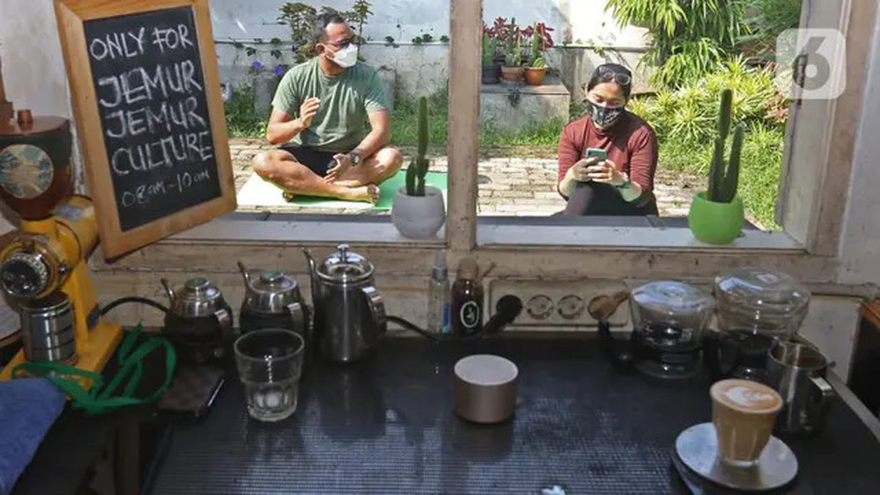 Pelanggan berjemur di halaman kedai kopi Nyambi Ngopi, Depok, Jawa Barat, Selasa (3/8/2021). Kedai kopi tersebut menjadikan halamannya untuk program Ngopi Sambil Berjemur pada pukul 09.00 - 1