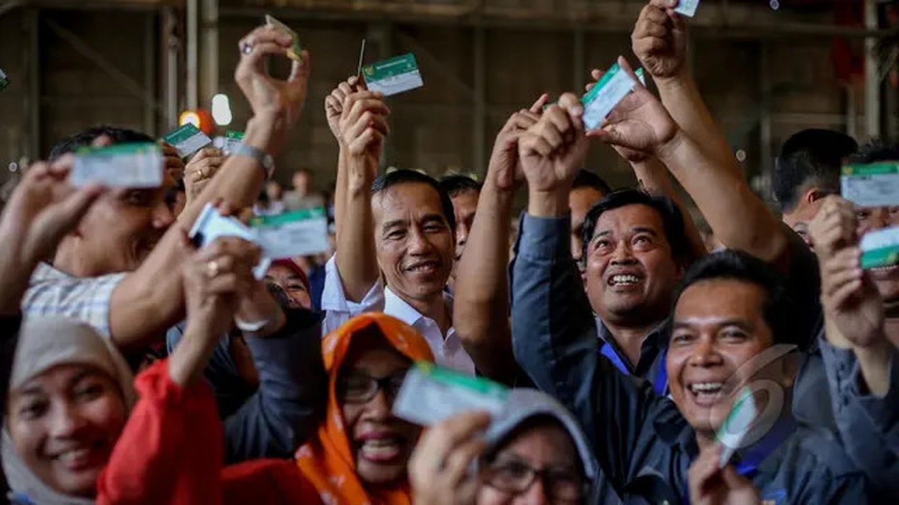 Presiden Joko Widodo (tengah) berfoto bersama para pekerja usai penyerahan Kartu Indonesia Sehat (KIS) untuk pekerja di PT Dok dan Perkapalan Kodja Bahari, Cilincing, Jakarta, Selasa (28/4/20