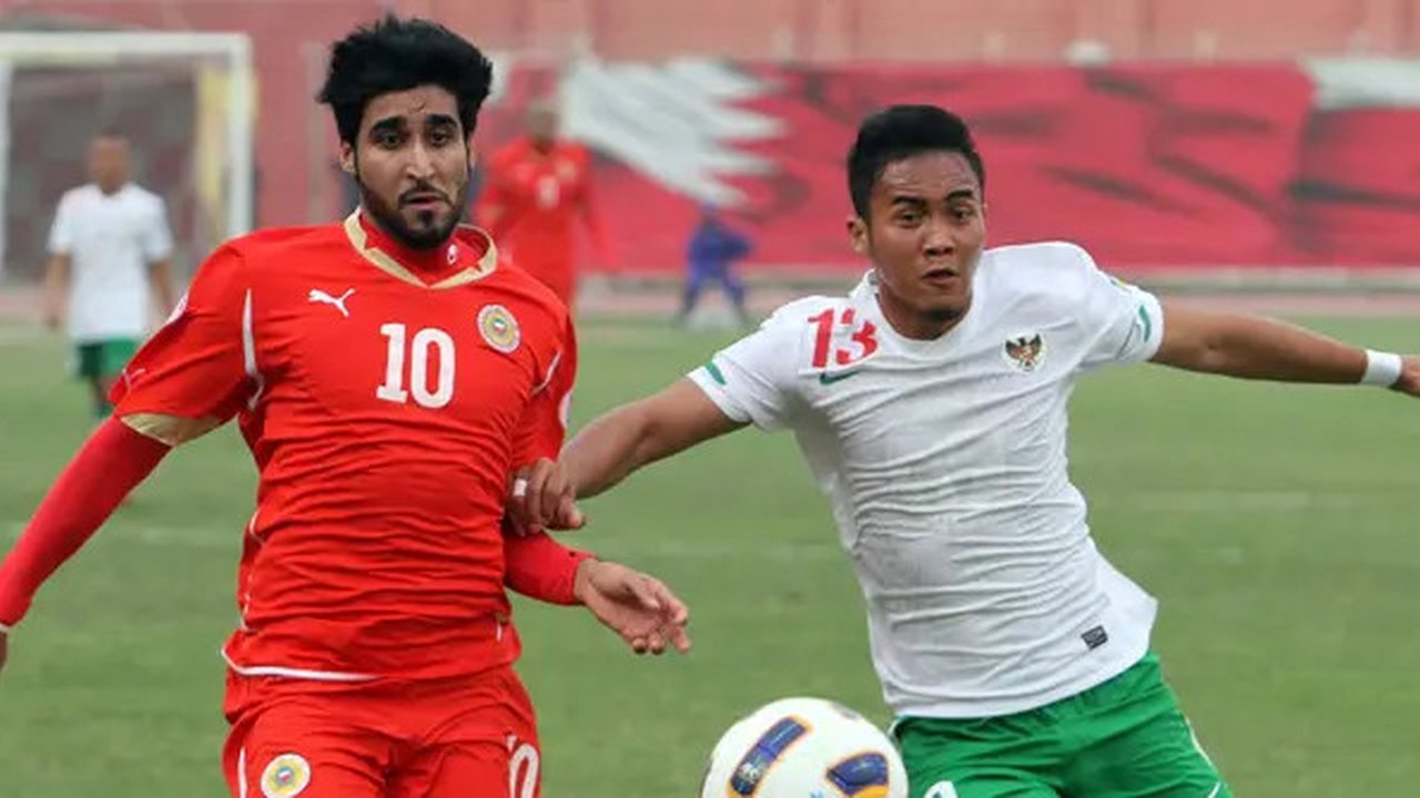 Bek Timnas Indonesia, Gunawan Dwi Cahyo mencoba menghadang pergerakan striker Bahrain, Mohammed Ali dalam laga Kualifikasi Piala Dunia 2014. Laga yang berlangsung di Stadion Nasional Rifaa pa