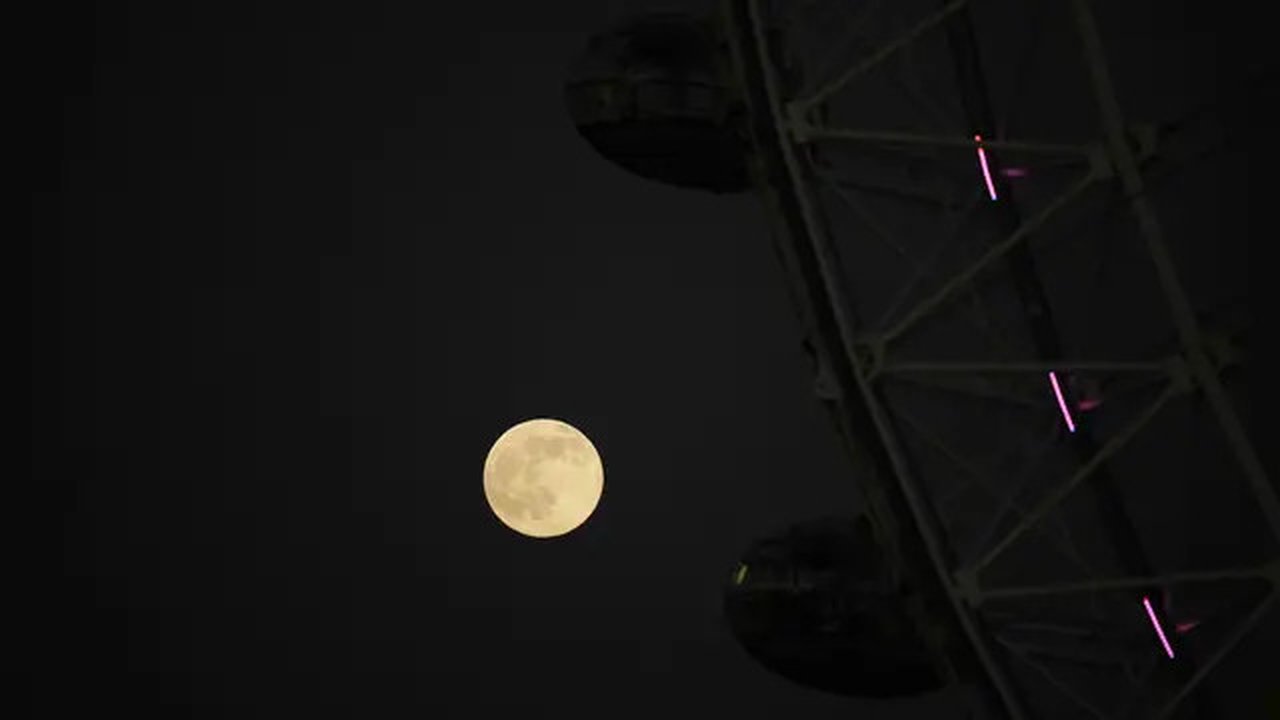 Bulan purnama pertama tahun yang dikenal sebagai Wolf Moon terlihat di belakang London Eye ferris Wheel, di London, Senin (17/1/2022). Wolf Moon atau disebut juga Bulan purnama Serigala adala