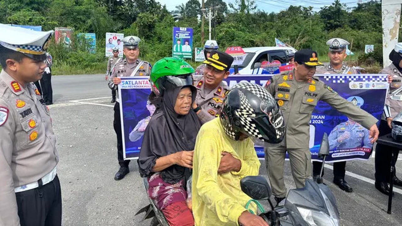 Polres Rokan Hulu membagikan helm kepada warga yang kedapatan tidak memakai helm saat naik motor. (Liputan6.com/M Syukur)