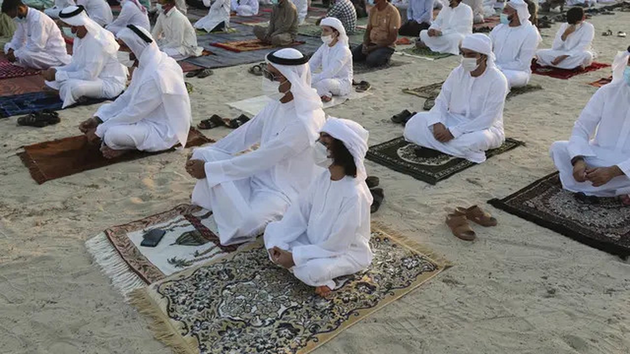 Umat Muslim yang mengenakan masker untuk meredam penyebaran wabah virus corona melaksanakan sholat Idul Fitri menandai akhir bulan suci Ramadhan di Dubai, Uni Emirat Arab, Kamis (13/5/2021).