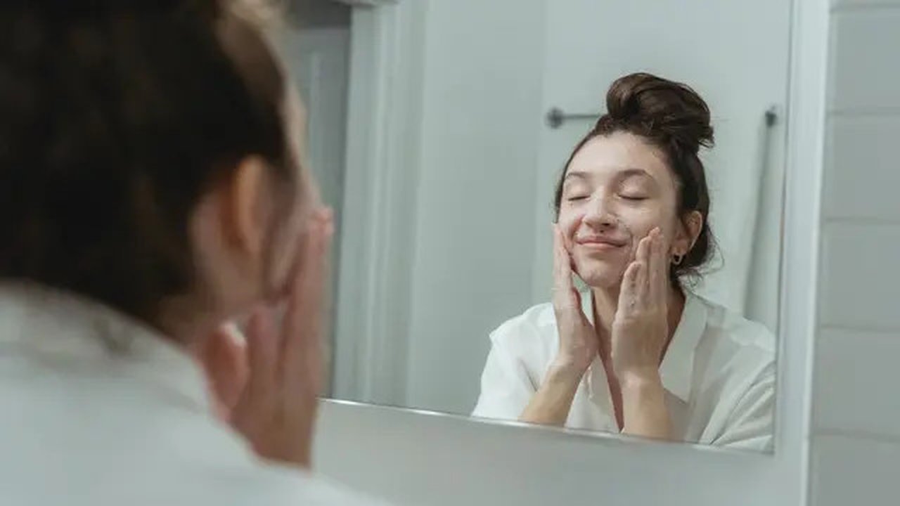 Ilustrasi perempuan yang sedang mencuci wajah menggunakan sabun cuci muka untuk kulit kering dan beruntusan. Credits: pexels.com by Miriam Alonso