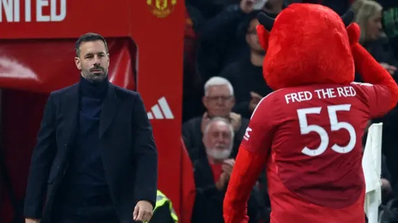 Manajer sementara Manchester United asal Belanda Ruud van Nistelrooy (L) disambut oleh maskot klub Fred The Red menjelang kick-off pada pertandingan babak 16 besar Piala Liga Inggris
