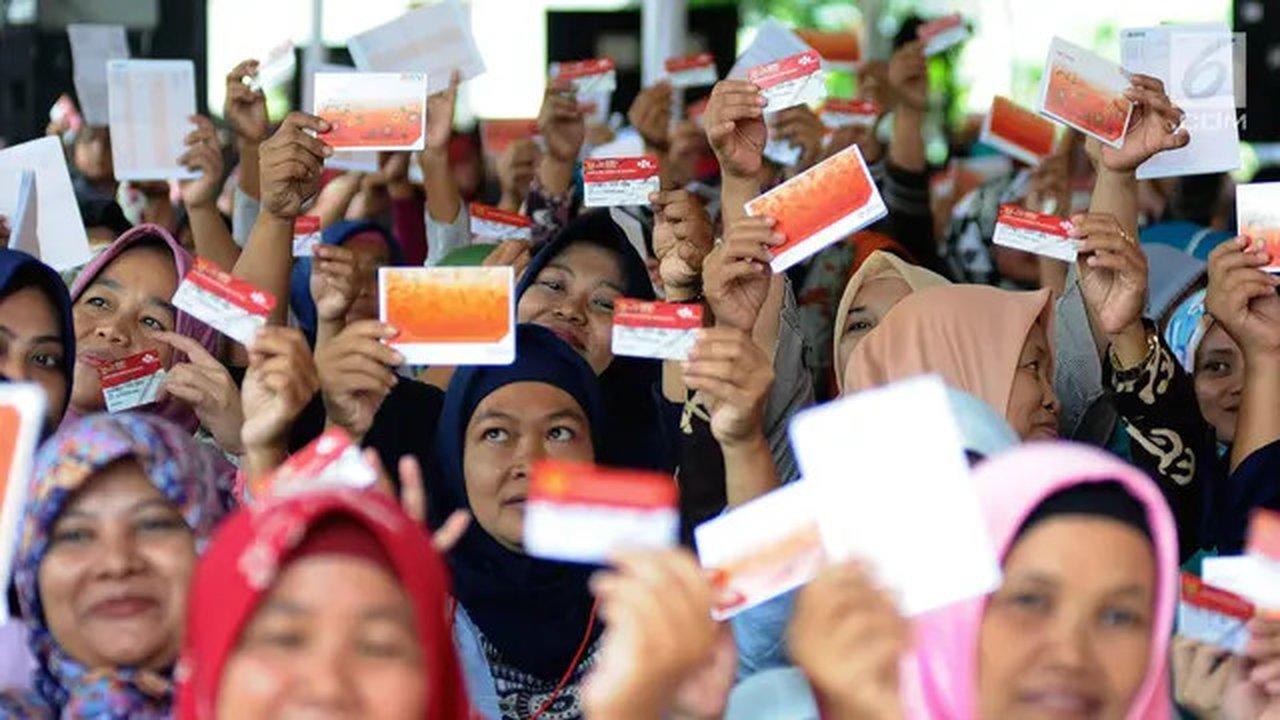 Warga menunjukkan KKS saat Penyaluran Bantuan Sosial PKH dan BPNT di Depok, Jawa Barat, Selasa (12/2).1000 orang warga Depok, Keluarga Penerima Manfaat (KPM) Program Keluarga Harapan (PKH) me