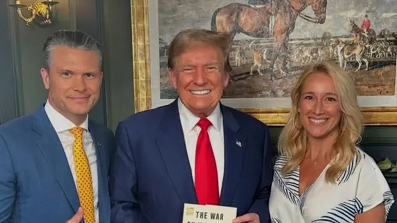 Pete Hegseth berpose dengan Donald Trump, yang memegang buku yang ditulisnya 