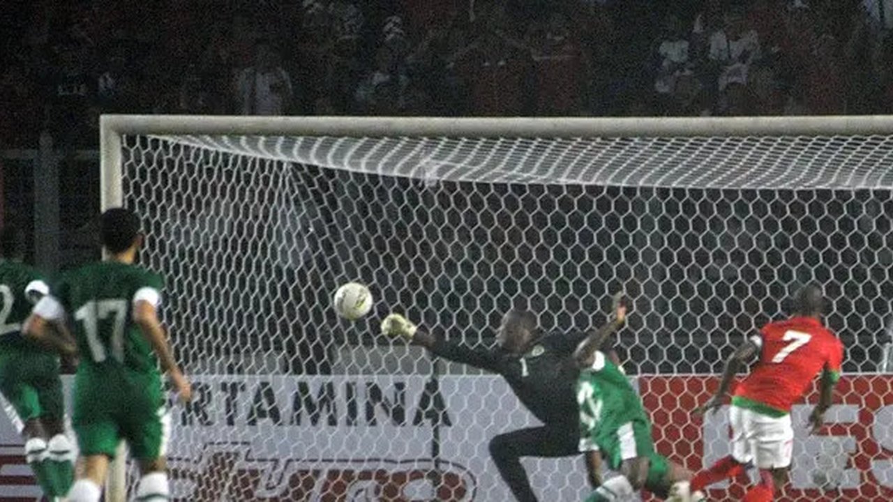 Striker Timnas Indonesia, Boaz Solossa mencetak gol ke gawang Timnas Arab Saudi dalam laga Grup C Kualifikasi Piala Asia 2015 di Stadion Utama Gelora Bung Karno, Jakarta pada Maret 2023. (AFP
