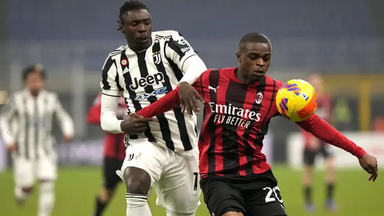 Penyerang Juventus Moise Kean berebut bola dengan bek AC Milan Pierre Kalulu pada laga pekan ke-23 Liga Italia musim 2021-22 di San Siro, Senin dini hari WIB (24/01/2022).  AC Milan harus pua