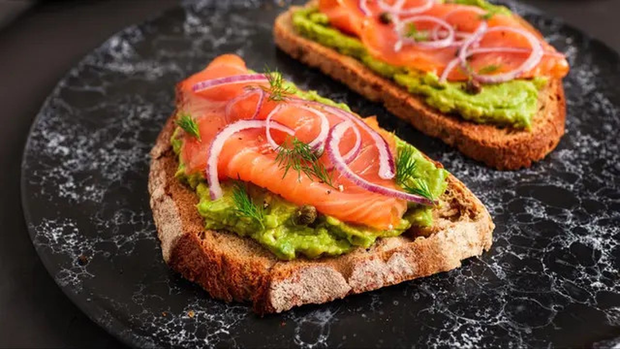 Roti gandum panggang dengan salmon asap dan potongan alpukat bisa jadi salah satu menu sarapan lainnya untuk diet Mediterania. (Foto: Mediterranean Living)