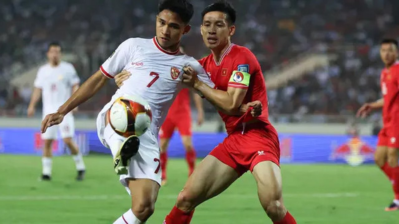Pemain Timnas Indonesia, Marselino Ferdinan (kiri) berebut bola dengan pemain Timnas Vietnam, Do Hung Dung pada laga Grup F Kualifikasi Piala Dunia 2026 di My Dinh Stadium, Vietnam, Selasa