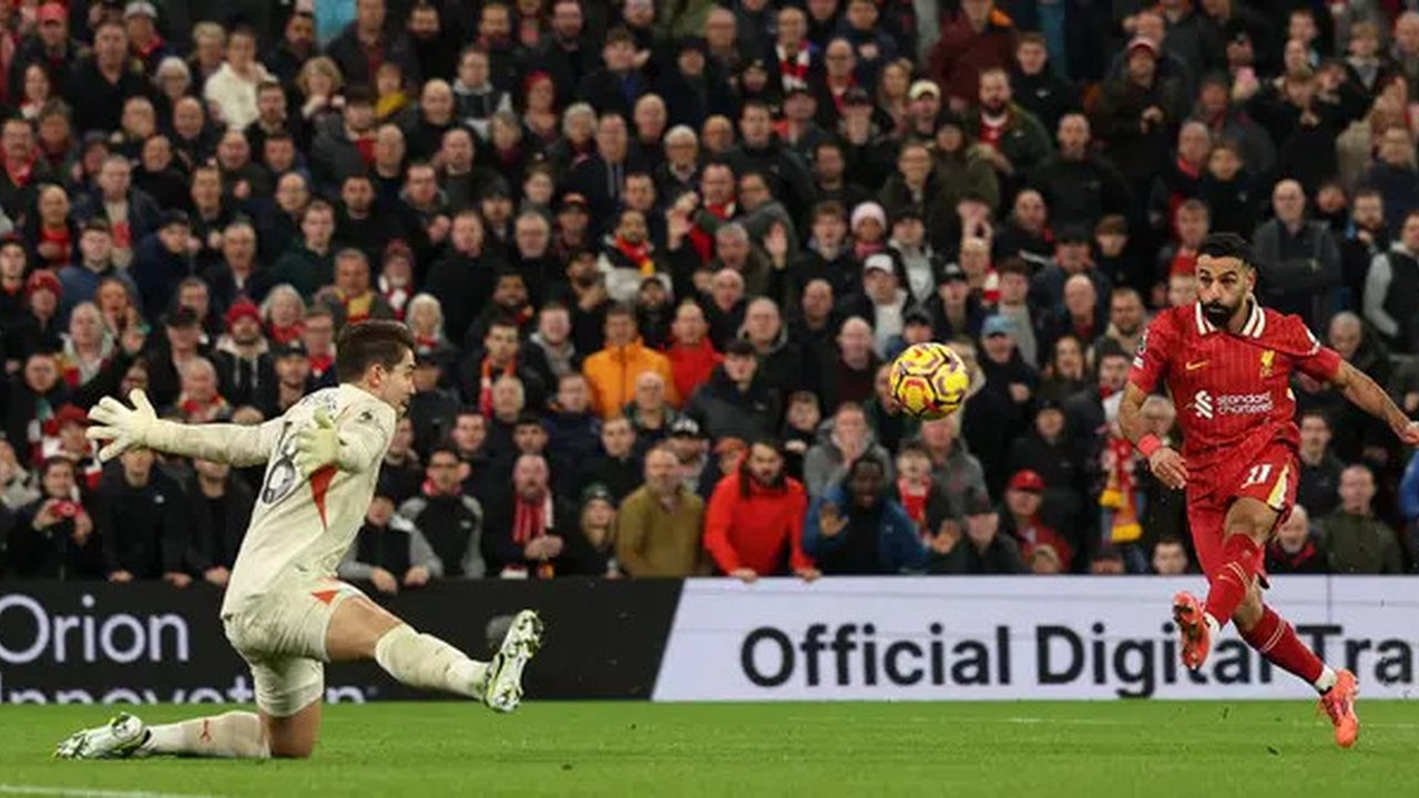 Penyerang Liverpool, Mohamed Salah, menjebol gawang kiper Man City, Stefan Ortega di Anfield, Senin (2/12/2024). (AFP/Adrian Denis)