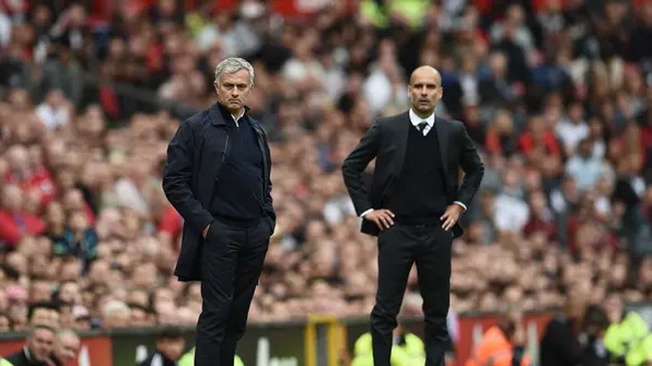 Aksi pelatih Manchester United, Jose Mourinho (kiri) dan pelatih  Manchester City, Pep Guardiola (R) saat menyaksikan anak asuhnya berlaga pada laga Premier League di Old Trafford, Manchester