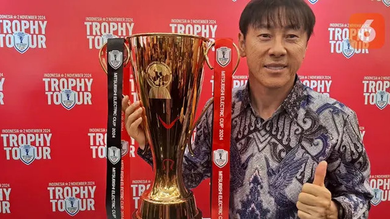 Pelatih Timnas Indonesia, Shin Tae-yong, berpose dengan trofi Piala AFF atau ASEAN Championship di FX Sudirman, Jakarta Pusat, Sabtu (2/11/2024). (Bola.com/Muhammad Adi Yaksa)