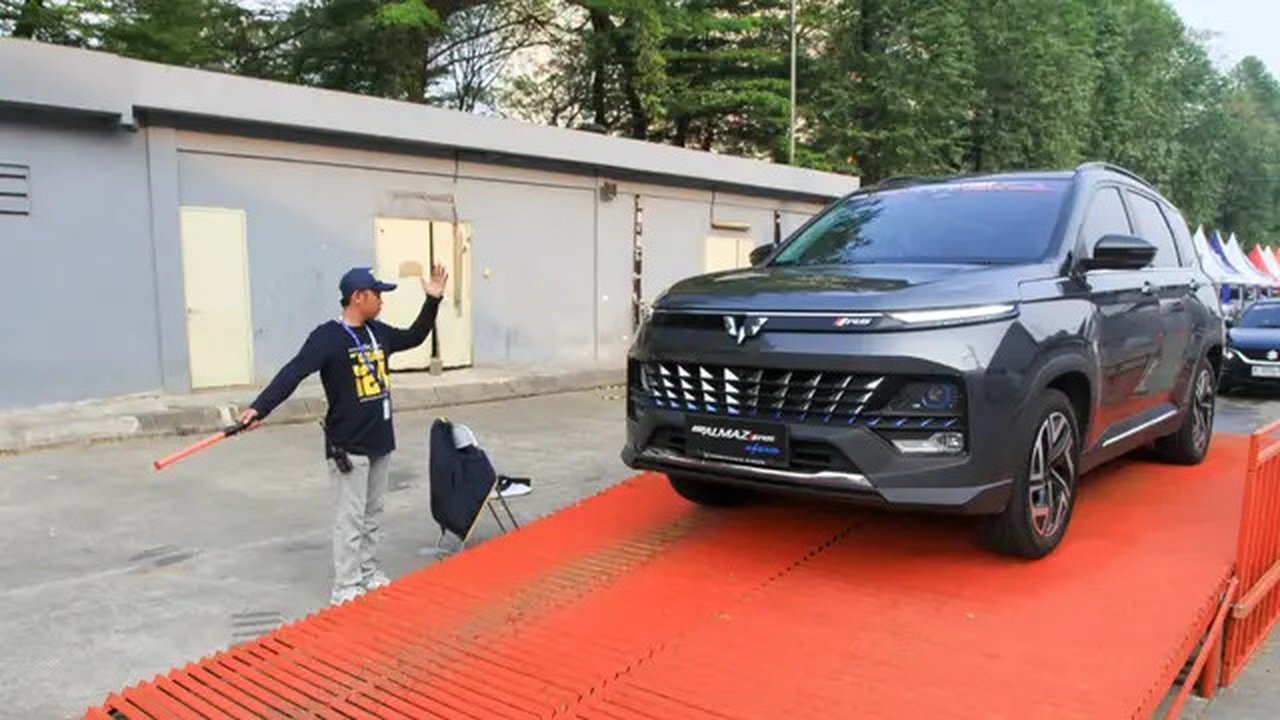 Pengunjung GIIAS 2024 melakukan test drive Wuling Almaz Pro Hybrid.