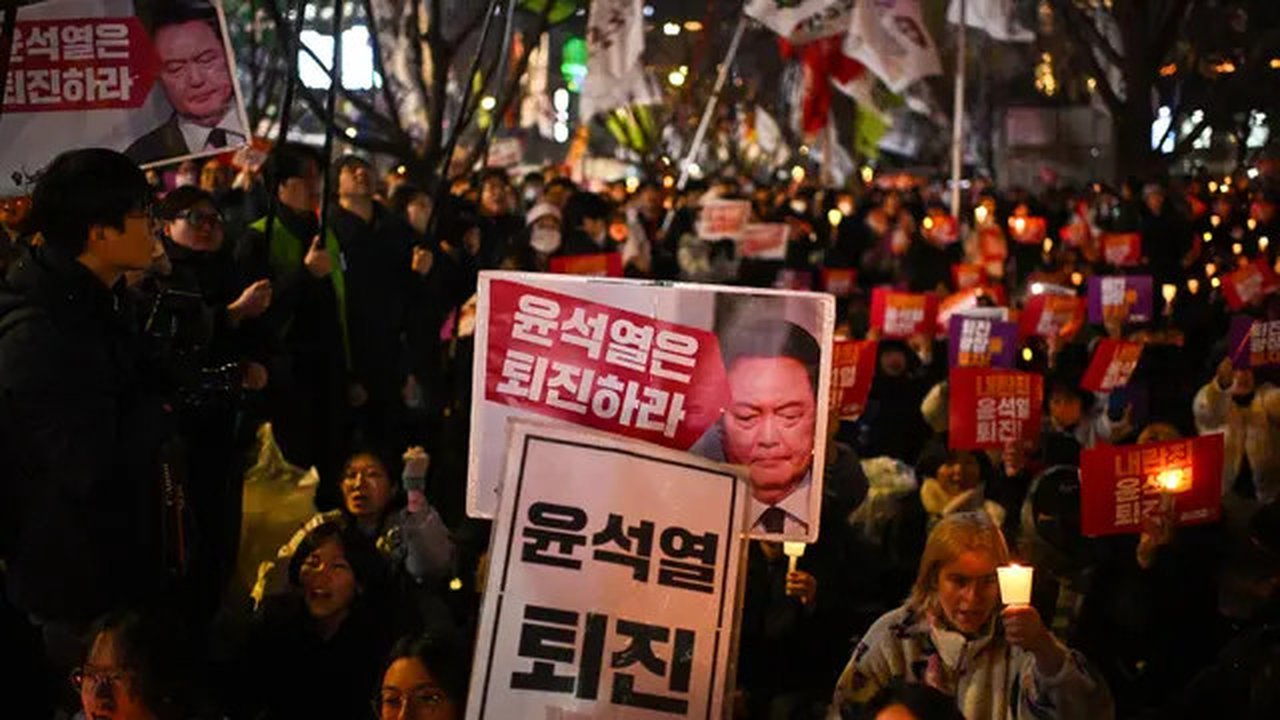 Keputusan Presiden Korea Selatan Yoon Suk Yeol terkait pemberlakuan darurat militer sontak mendorong ribuan orang untuk berkumpul di depan parlemen untuk melakukan protes. (Philip FONG/AFP)