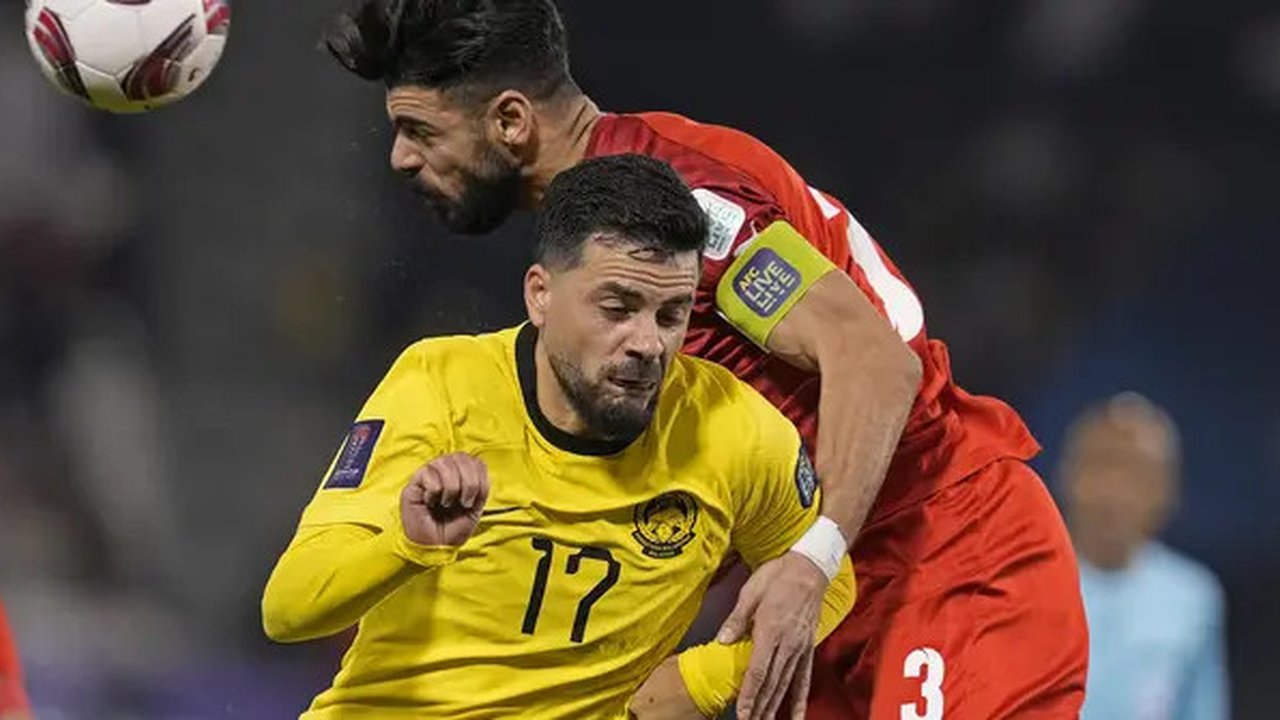 Bek sekaligus kapten Timnas Bahrain, Waleed Al Hayyam (kanan) menghalau bola dengan sundulan kepala dari ancaman striker Malaysia, Paulo Josue pada laga kedua Grup E Piala Asia 2023 di Jassim