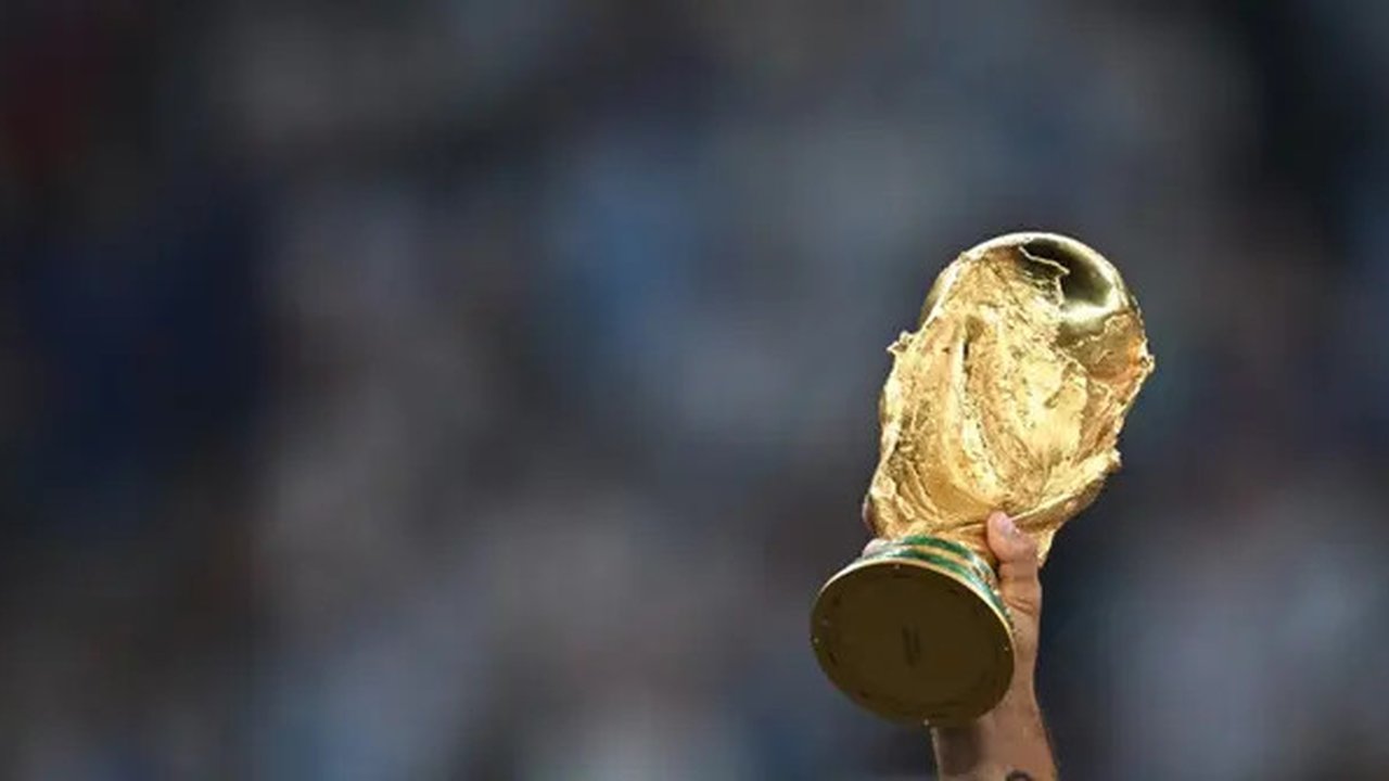 Trofi Piala Dunia FIFA diangkat tinggi-tinggi saat para pemain Argentina merayakan kemenangan mereka atas Prancis di lapangan setelah pertandingan final Piala Dunia Qatar 2022 antara Argen