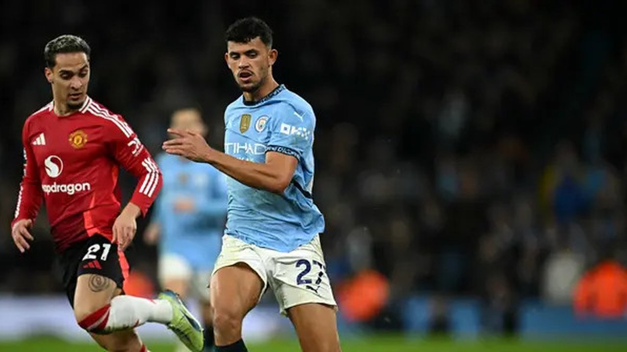 Gelandang Manchester City asal Portugal Matheus Nunes berebut bola dengan gelandang Manchester United asal Brasil Antony selama pertandingan sepak bola Liga Primer Inggris antara Mancheste