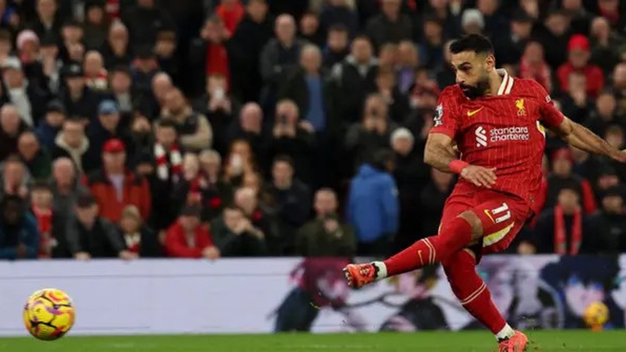 Penyerang Liverpool asal Mesir #11, Mohamed Salah, melepaskan tendangan penalti untuk mencetak gol kedua tim selama pertandingan Liga Primer Inggris antara Liverpool dan Manchester City di