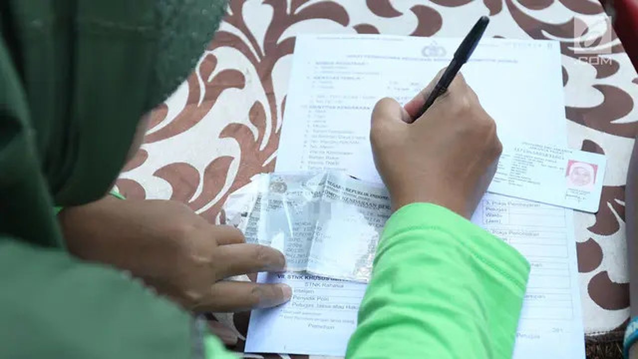 Warga mengisi formulir untuk membayar pajak kendaraan bermotor di gerai Samsat Keliling Car Free Day, Jakarta, Minggu (21/10). Agar bisa membayar pajak ini cukup menggunakan STNK dengan nama