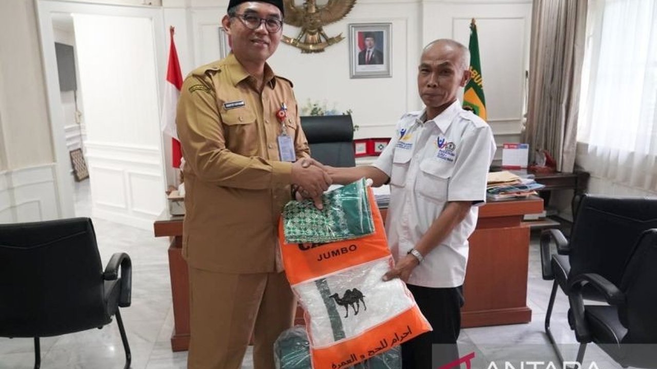 Sekretaris Daerah Kabupaten Bogor memberikan hadiah umrah kepada Ahmad Samsudin, guru SLB Mekarsari 1 Cibinong, atas dedikasinya selama 24 tahun dalam mendidik anak berkebutuhan khusus.