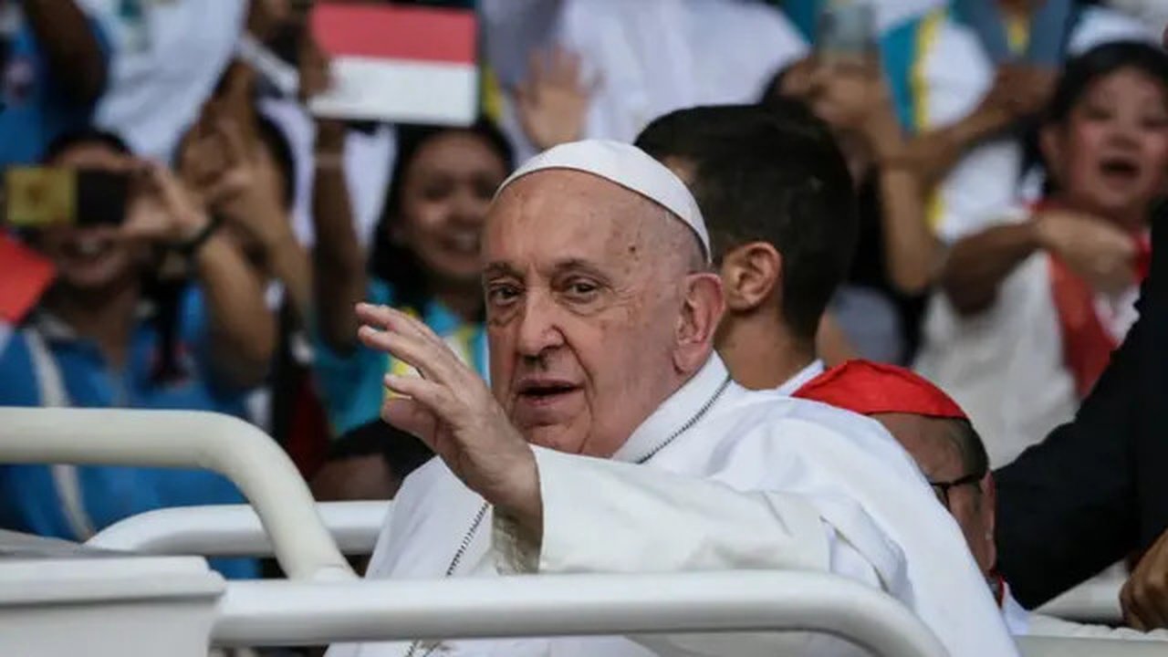Paus Fransiskus bereaksi di dalam mobil saat tiba untuk memimpin misa di Stadion Gelora Bung Karno di Jakarta pada 5 September 2024. (ADITYA AJI/POOL /AFP)