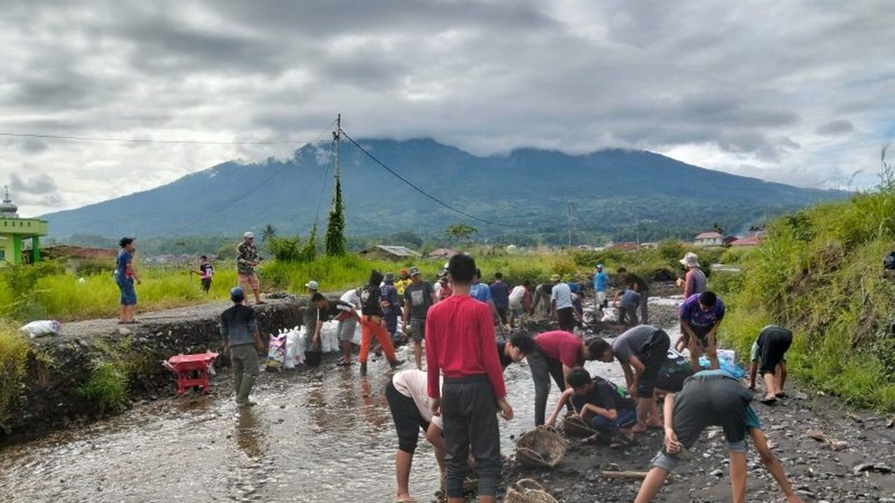 Puluhan warga dan santri di Jorong Cangkiang, Agam, Sumatera Barat, bergotong royong memperbaiki akses jalan yang rusak akibat banjir lahar dingin Gunung Marapi pasca bencana Mei 2024.