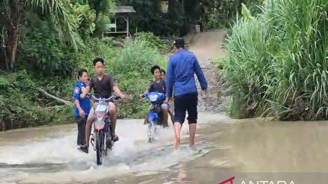 Petugas Damkarmat Lampung Selatan membantu warga menyeberangi sungai setelah jembatan penghubung antar kecamatan di Desa Suak, Kecamatan Sidomulyo putus akibat banjir pada Senin, 20 Januari 2024.