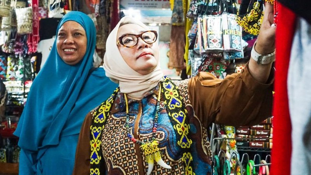 Menteri Pemberdayaan Perempuan dan Perlindungan Anak, Arifah Fauzi, membeli kerajinan tangan khas Kalimantan Timur di Pasar Inpres Kebun Sayur Balikpapan, memberikan dukungan nyata pada UMKM lokal.