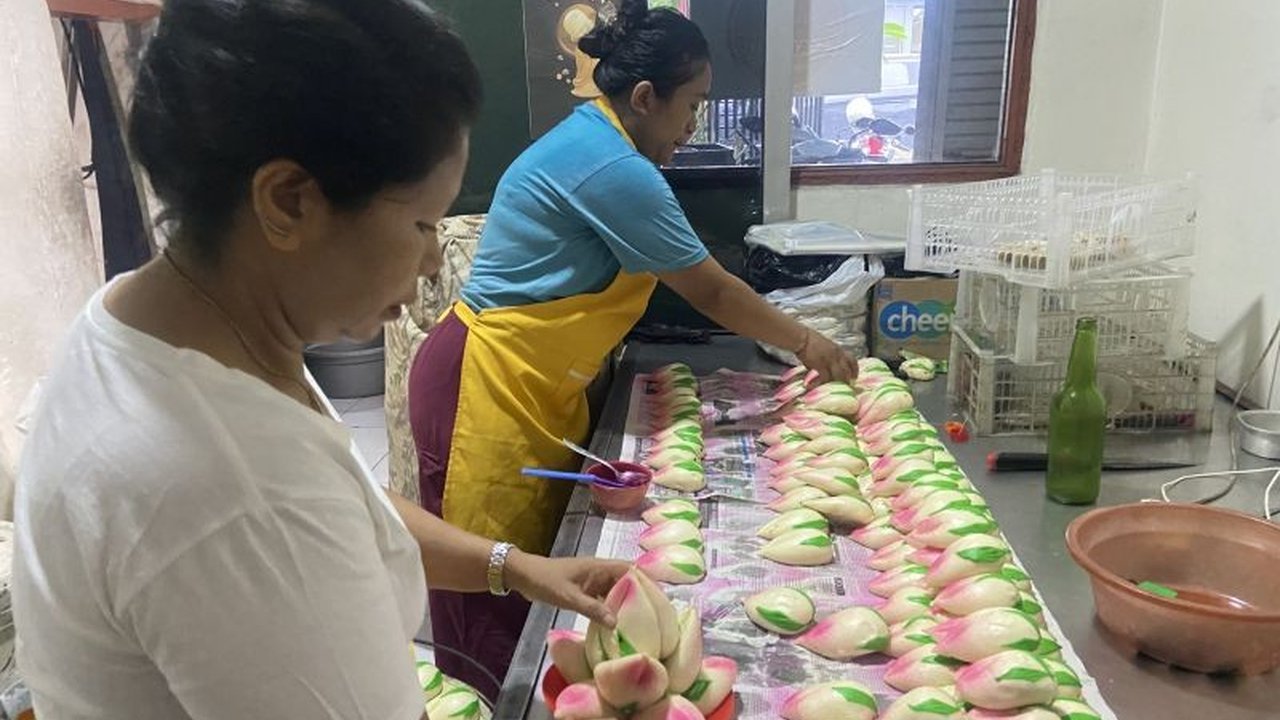 Menjelang Imlek 2576, UMKM rumahan di Denpasar, Bali, milik Ni Wayan Raba kebanjiran pesanan kue teratai hingga puluhan kilogram, menunjukkan tradisi unik perayaan Imlek di Bali.