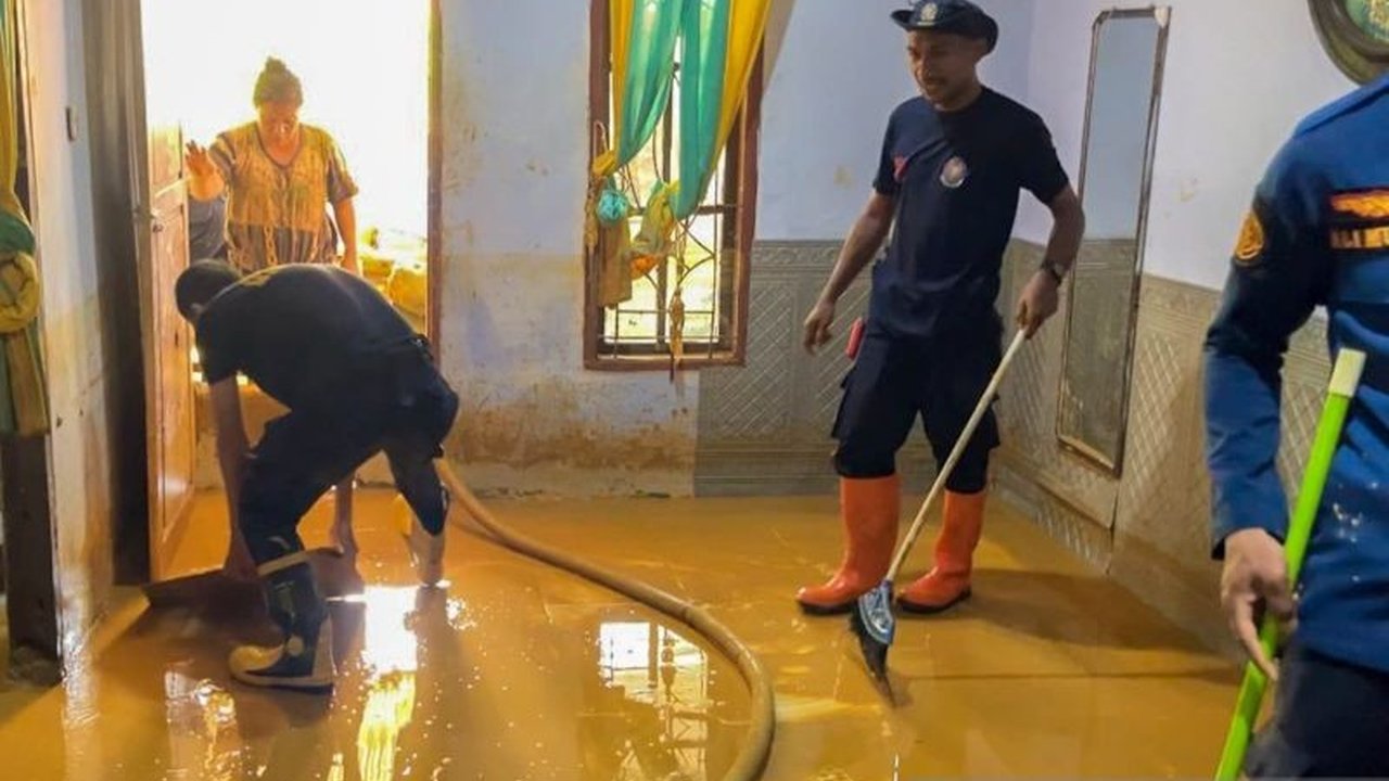 Petugas Damkar Kota Kendari membersihkan lumpur di rumah warga setelah banjir bandang melanda beberapa wilayah, mengakibatkan kerugian materiil dan puluhan kepala keluarga terdampak.