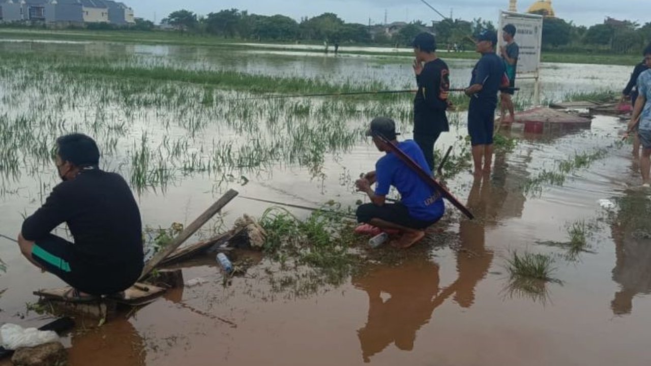 Ratusan warga Rorotan, Jakarta Utara, berburu ikan yang keluar dari tambak akibat banjir bandang yang melanda wilayah tersebut, memanfaatkan situasi untuk mencari tambahan penghasilan.
