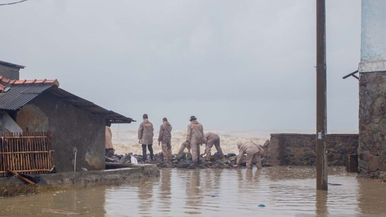 Polisi Bantu Tutup Tanggul Jebol Akibat Banjir Rob di Indramayu