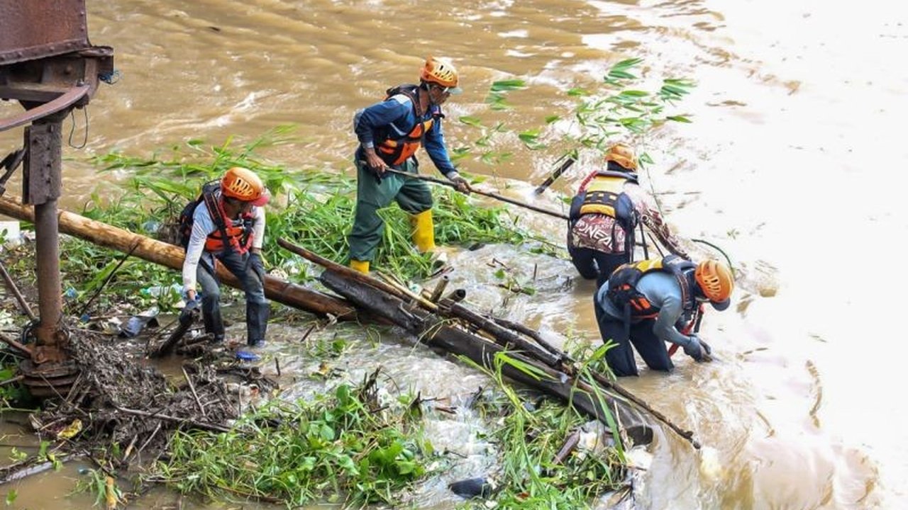 Pemkot Kediri kerahkan tim gabungan untuk membersihkan sampah bambu dan dahan yang menumpuk di kaki Jembatan Lama, guna mencegah kerusakan jembatan bersejarah dan banjir.