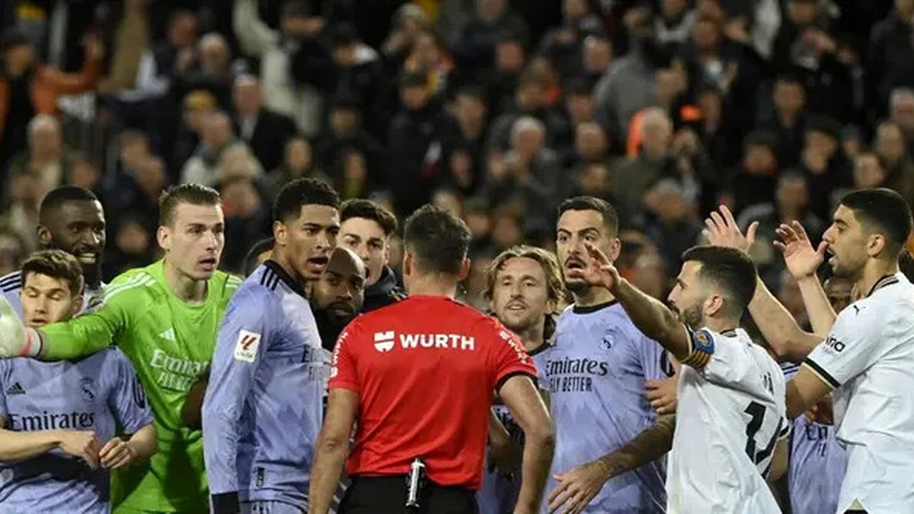 Wasit Spanyol Jesus Gil Manzano (belakang) berbicara dengan gelandang Inggris Real Madrid #5 Jude Bellingham selama pertandingan sepak bola liga Spanyol antara Valencia CF dan Real Madrid