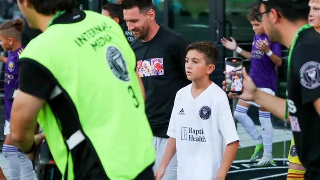 Pemain depan Inter Miami asal Argentina, Lionel Messi (tengah-kiri), dan putranya, pemain U-12 Inter Miami, Thiago Messi (tengah-kanan), tiba di lapangan untuk pertandingan perdana Inter M