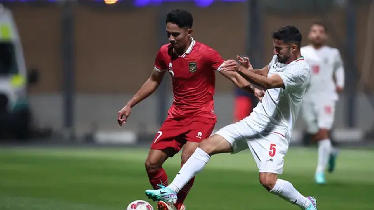 Gelandang Timnas Indonesia, Marselino Ferdinan (kiri) berebut bola dengan bek Timnas Iran, Milad Mohammadi pada laga uji coba terakhir menjelang Piala Asia 2023 di Al Rayyan Training Ground,