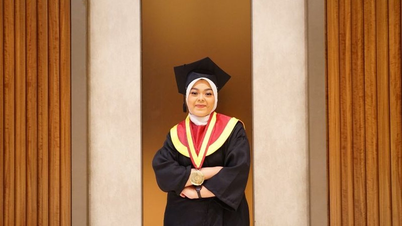 Ragita Dwi Nur Rahmadiani, seorang satpam di UM Surabaya, berhasil lulus cumlaude dengan IPK 3.8, membuktikan bahwa keterbatasan ekonomi bukan penghalang meraih mimpi.
