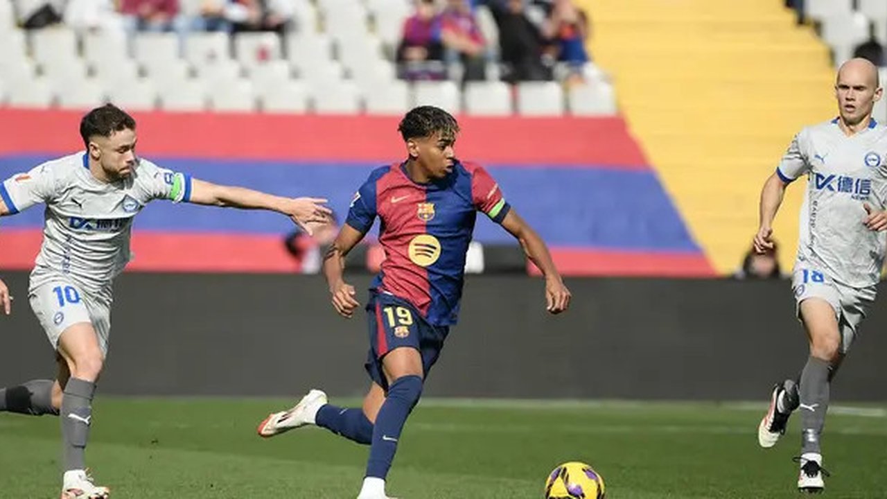 Pemain Barcelona, Lamine Yamal menggiring bola melewati penjagaan dari sejumlah pemain Deportivo Alaves dalam laga lanjutan Liga Spanyol 2024/2025 di Estadi Olimpic Lluis Companys, Barcelona,