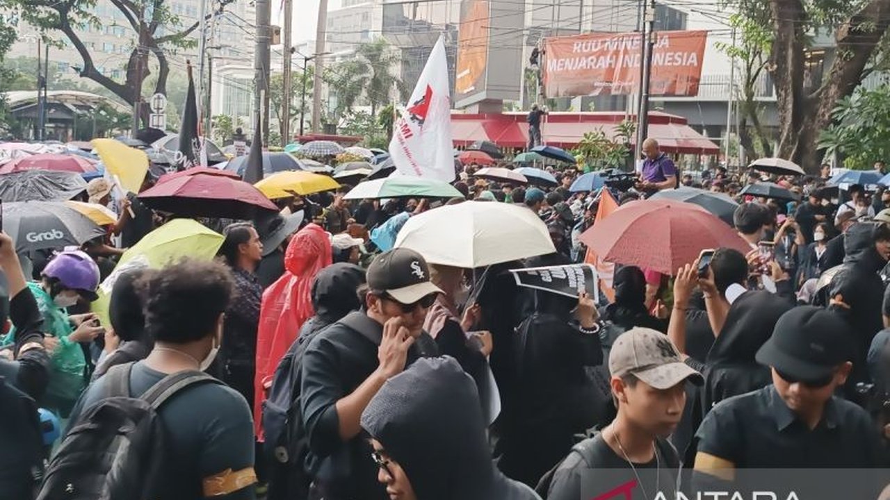Massa aksi di Patung Kuda, Jakarta Pusat, tetap bertahan meski hujan deras mengguyur, menuntut pengesahan RUU Perlindungan Pekerja Rumah Tangga dan RUU Minerba.