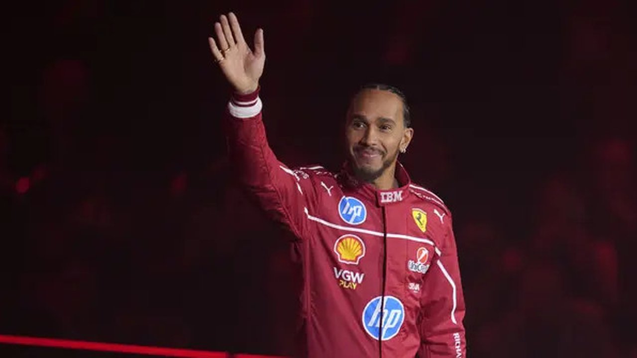 Pembalap Ferrari, Lewis Hamilton melambaikan tangan saat peluncuran tim Formula 1 untuk musim 2025 yang bertajuk 'F1 75' di O2 Arena, London, Selasa (18/02/2025). (AP Photo/Kin Cheung)