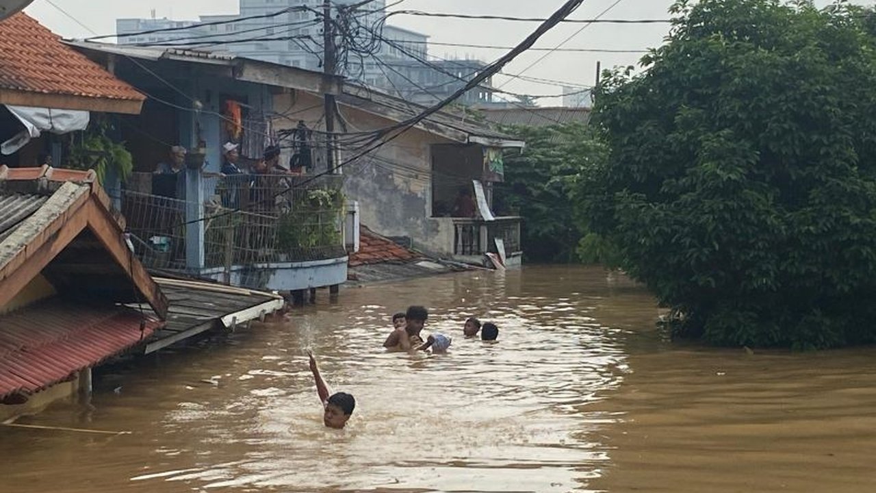 Banjir setinggi tiga meter di Rawajati, Jakarta Selatan, tak menyurutkan sejumlah anak untuk berenang, menciptakan pemandangan yang memprihatinkan sekaligus mengundang pertanyaan tentang keselamatan mereka.
