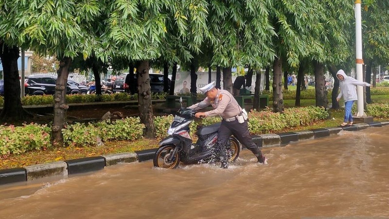 Polisi melakukan rekayasa lalu lintas di persimpangan Pasar Puri, Jakarta Barat, akibat banjir yang mencapai selutut orang dewasa dan menyebabkan beberapa kendaraan mogok.